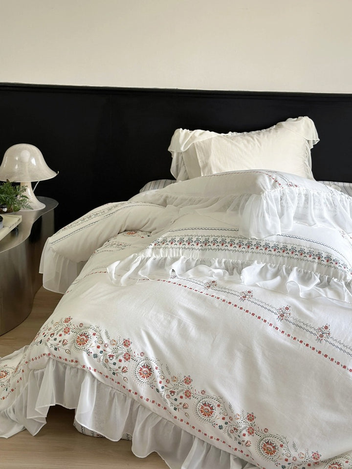 Lightly washed cotton bedding set with ruffled border and fine floral embroidery