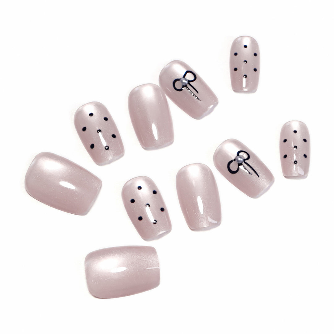 Artificial nail extensions with decorative bows and dots Stornfield
