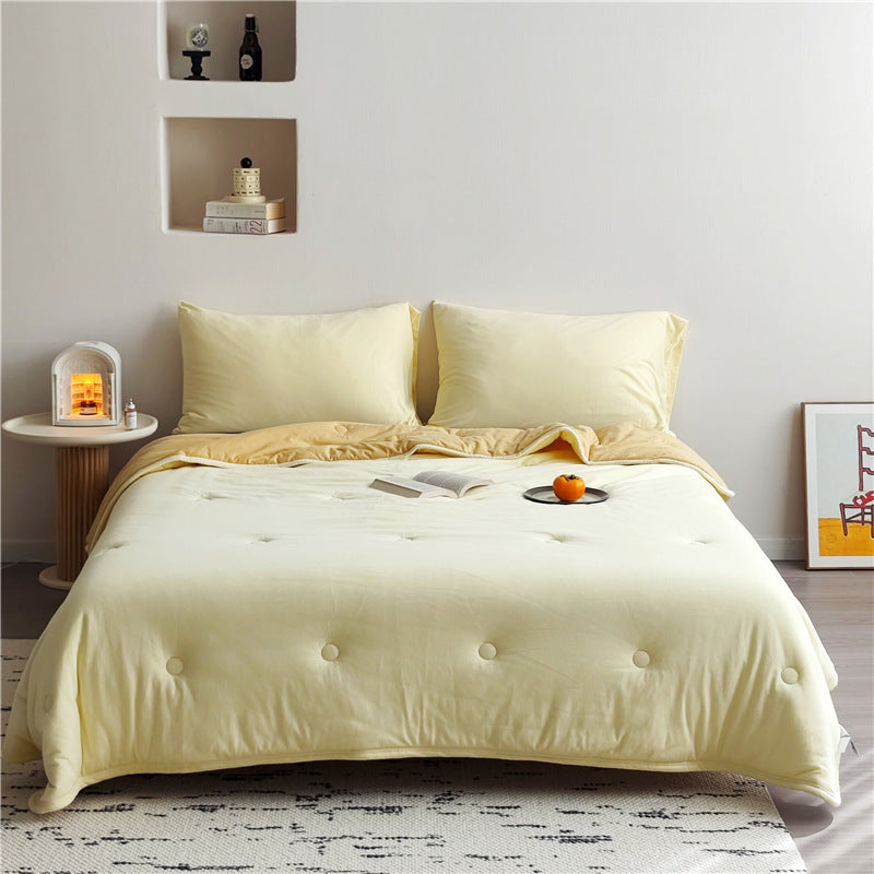 Light reversible quilted blanket made of microfiber with soft decorative stitching
