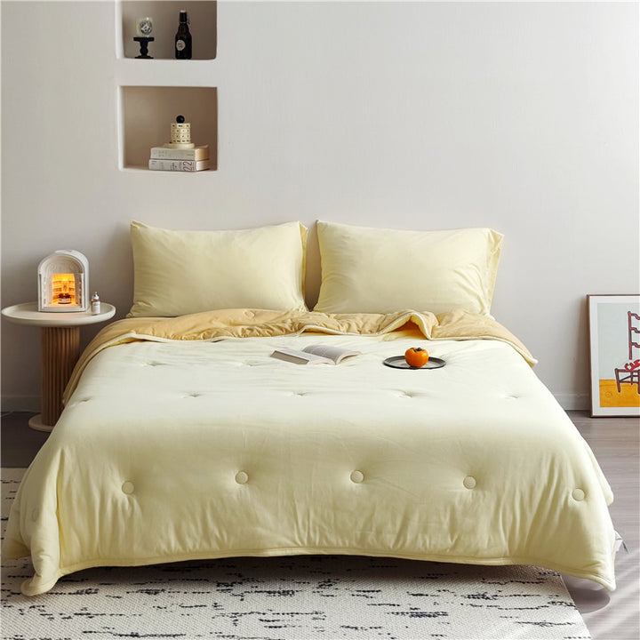 Light reversible quilted blanket made of microfiber with soft decorative stitching
