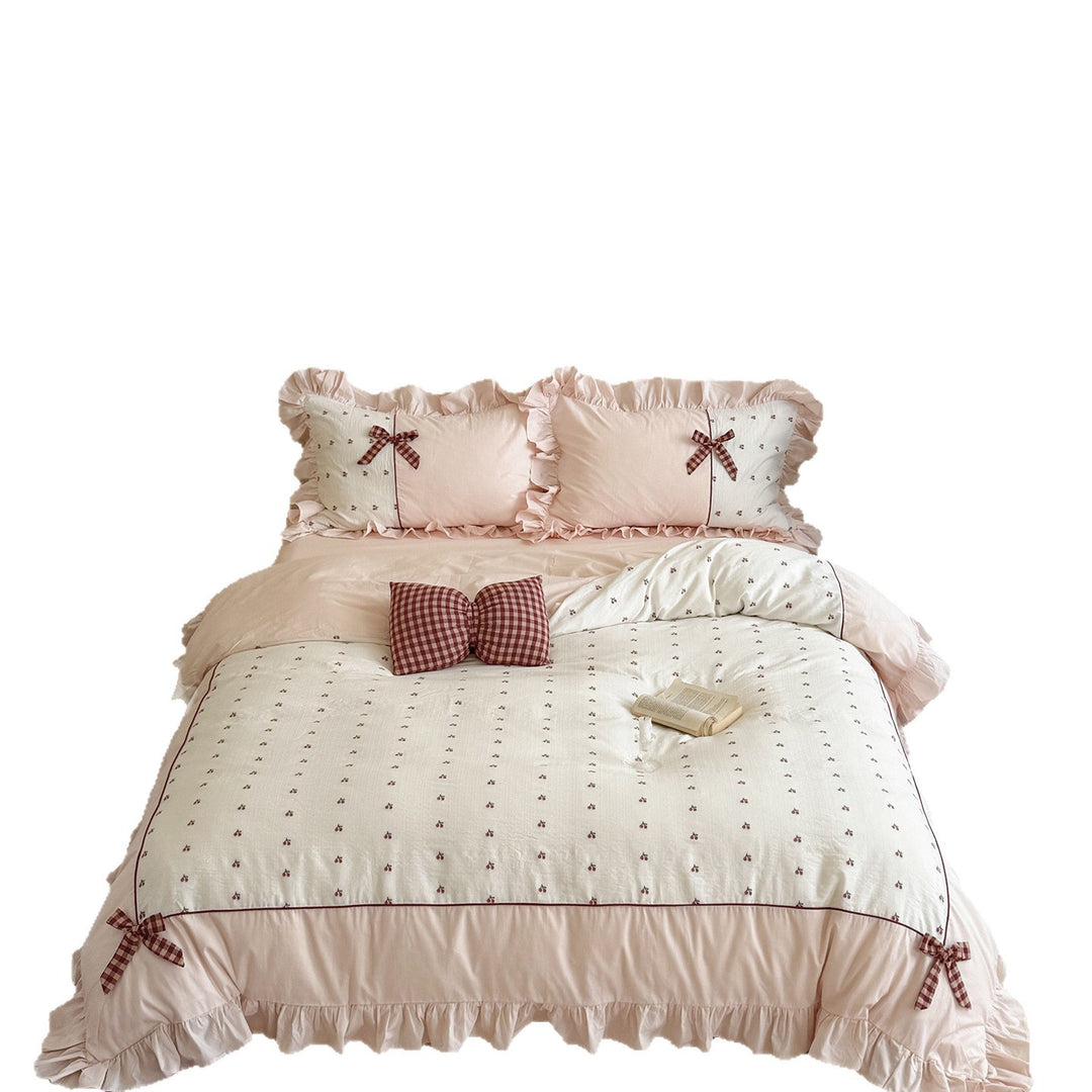 Playful ruffled bed set made of cotton muslin with embroidered cherries and checkered bows