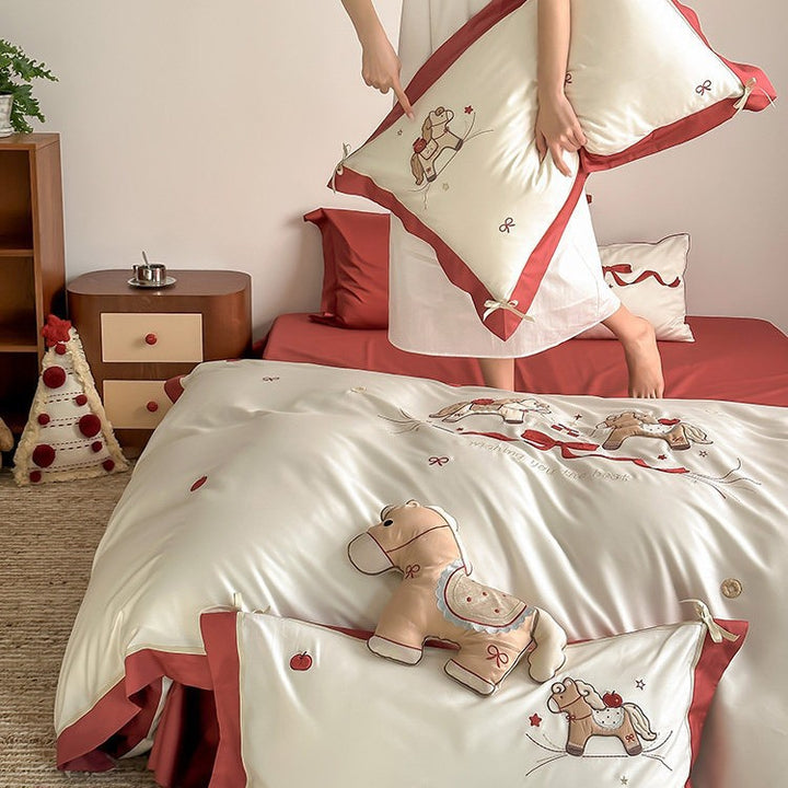 Children's bedding set made of cotton satin with embroidered rocking horse motif and contrasting hem