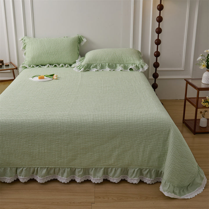 Quilted bed cover set with ruffled hem and lace trim