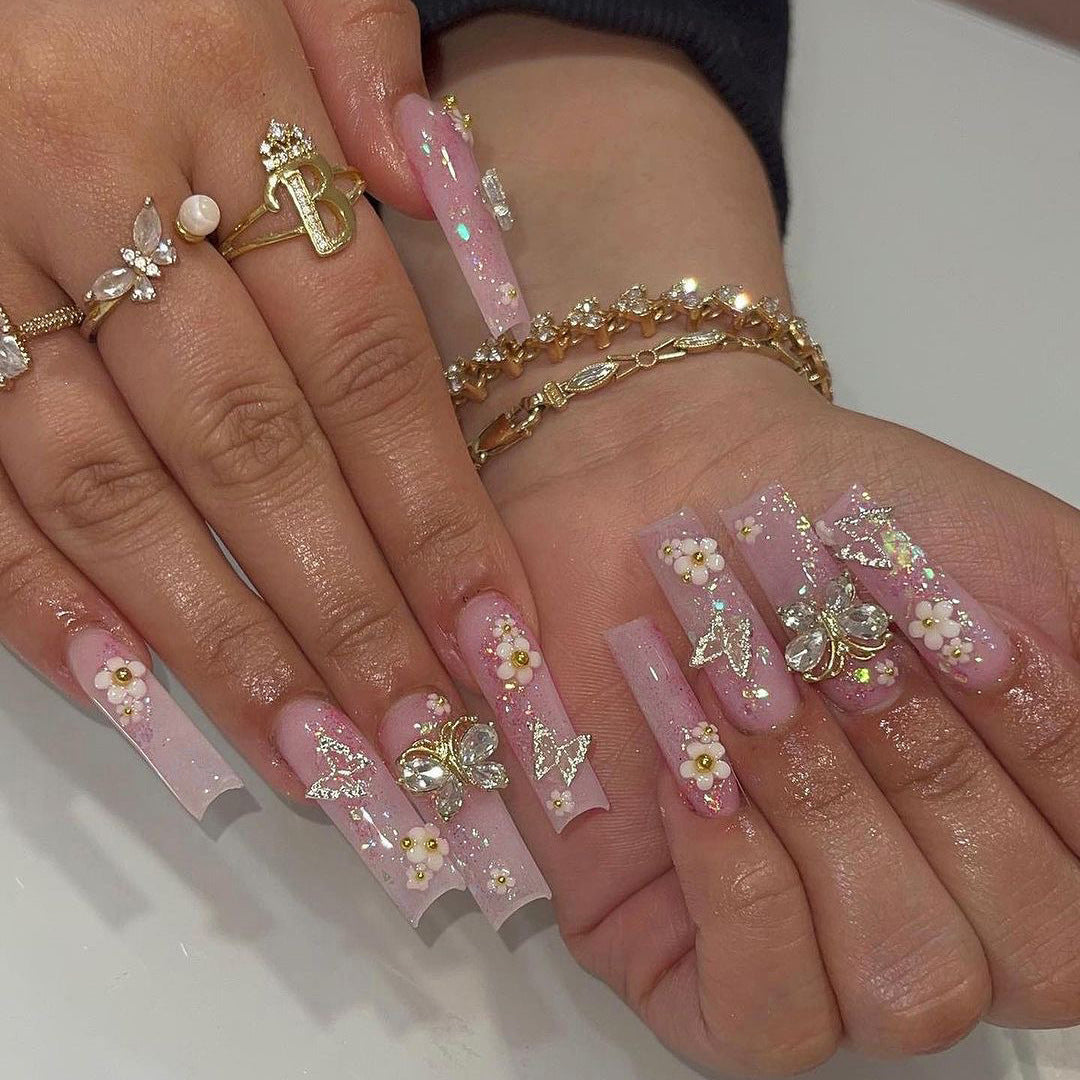 Artistic Nail Extensions with Glitter and Floral Accents Stornfield