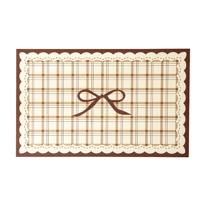 Rectangular wipeable placemat with checked pattern, wavy decorative edge and bow motif Stornfield