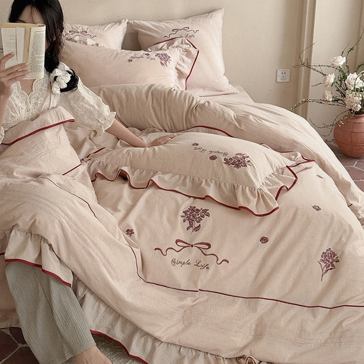 Cotton muslin bedding set with delicate floral embroidery, ruffle, and breathable finish