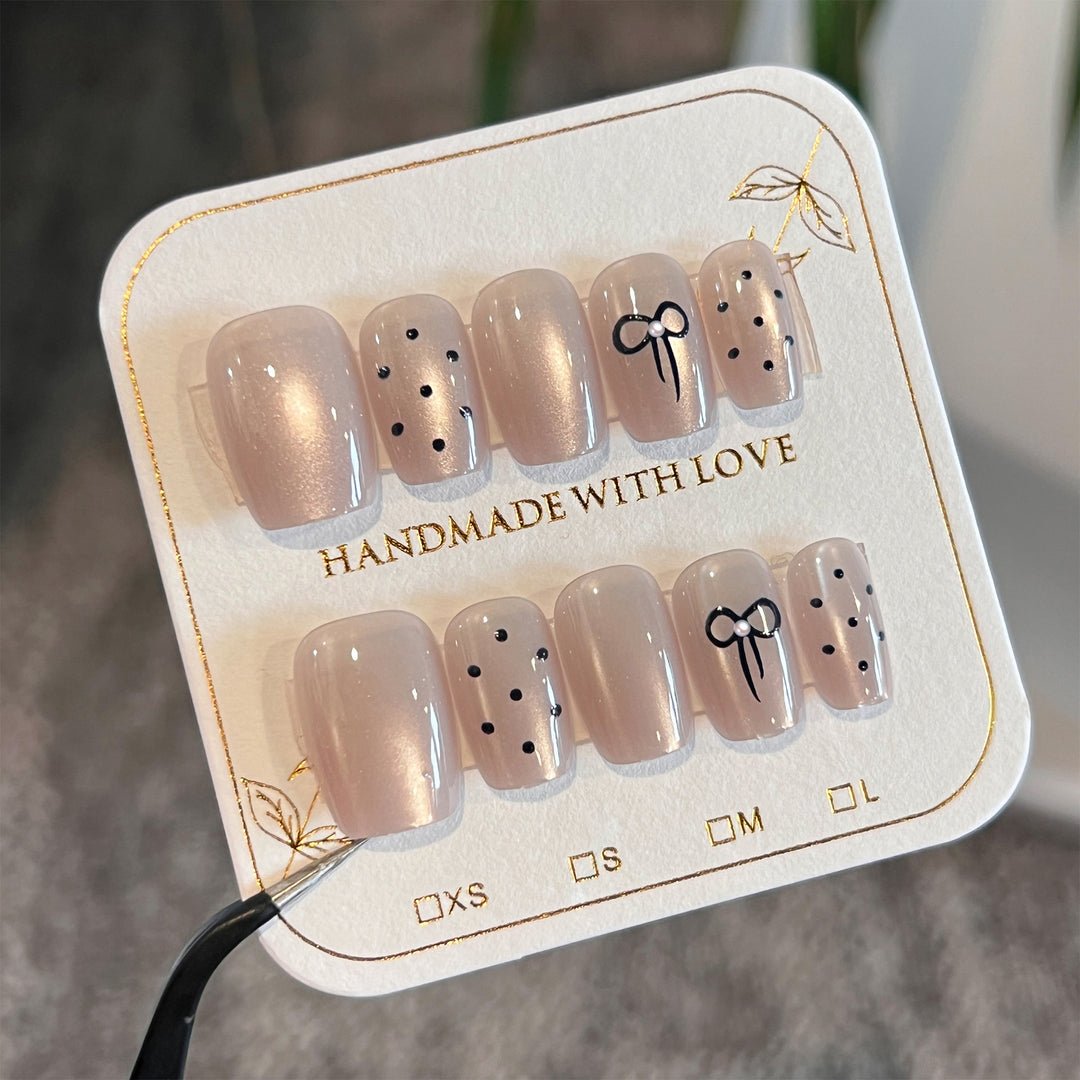 Artificial nail extensions with decorative bows and dots Stornfield