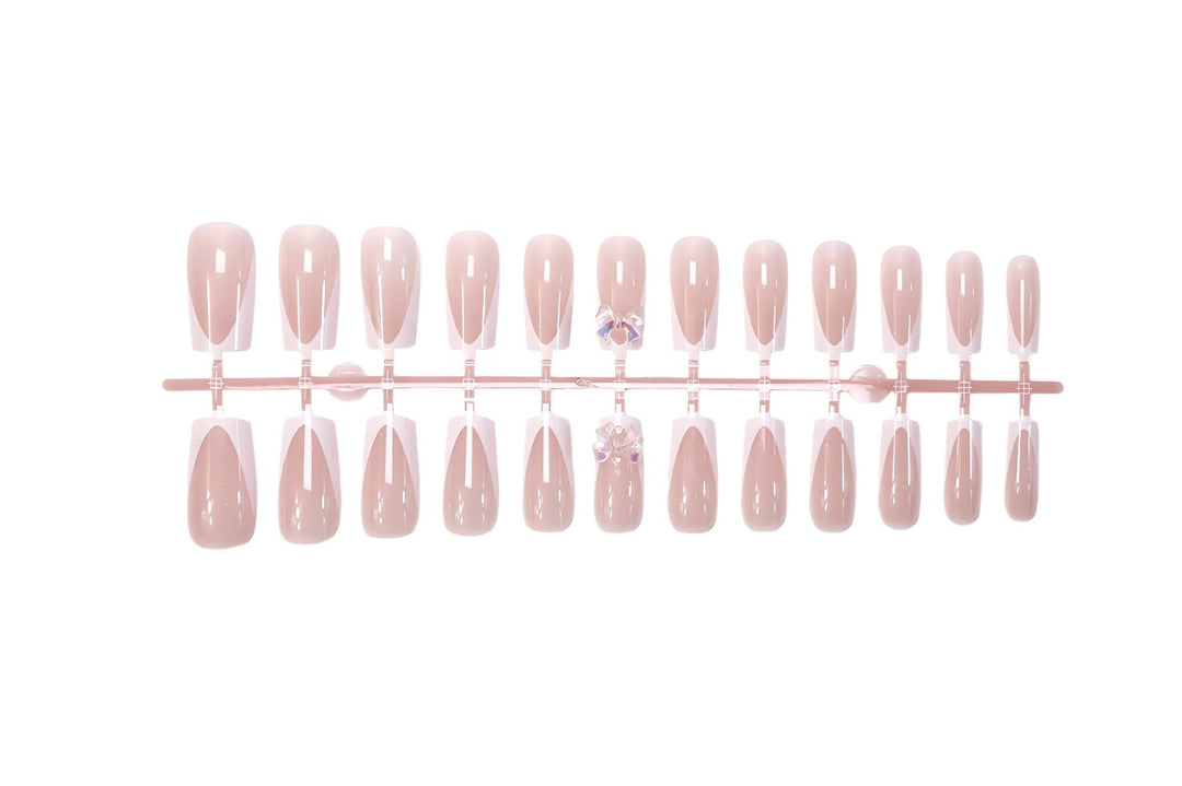 Artificial nail set with luxurious French tips and elegant jewelry embellishments Stornfield
