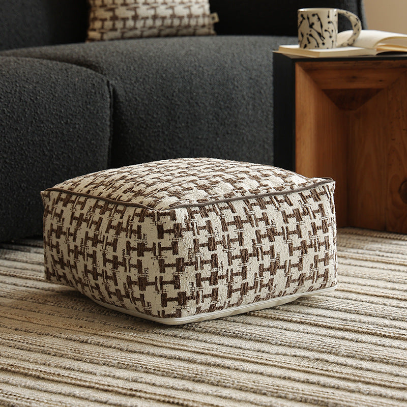 Square floor pouf with houndstooth jacquard, piping seam, and shape-stable foam core