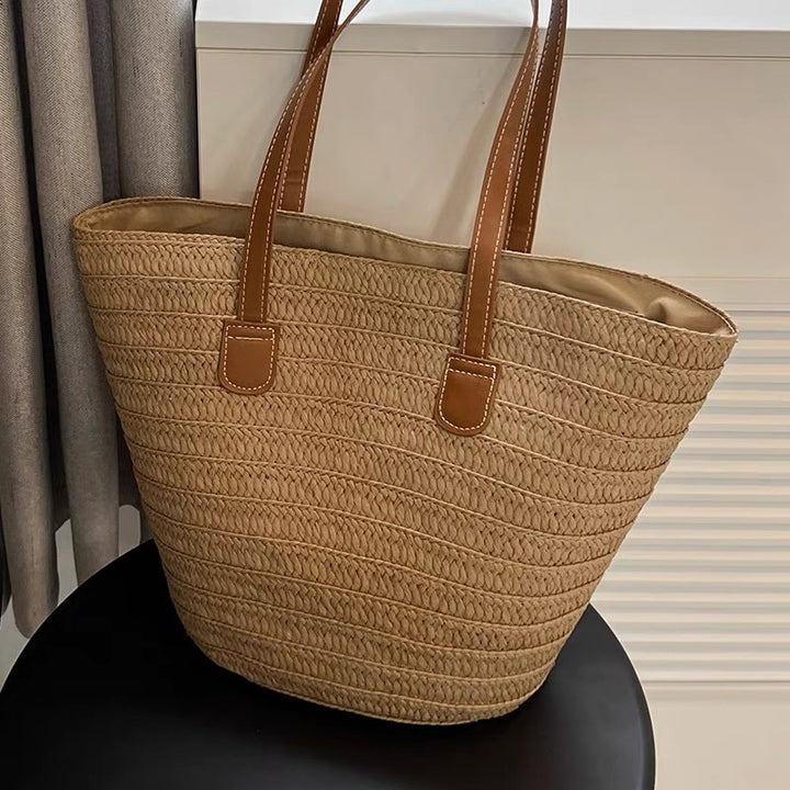 Stylish beach bag made of woven natural material with leather handles Stornfield