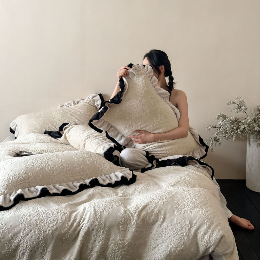 Quilted bedding set with floral embossing and ruffled frills