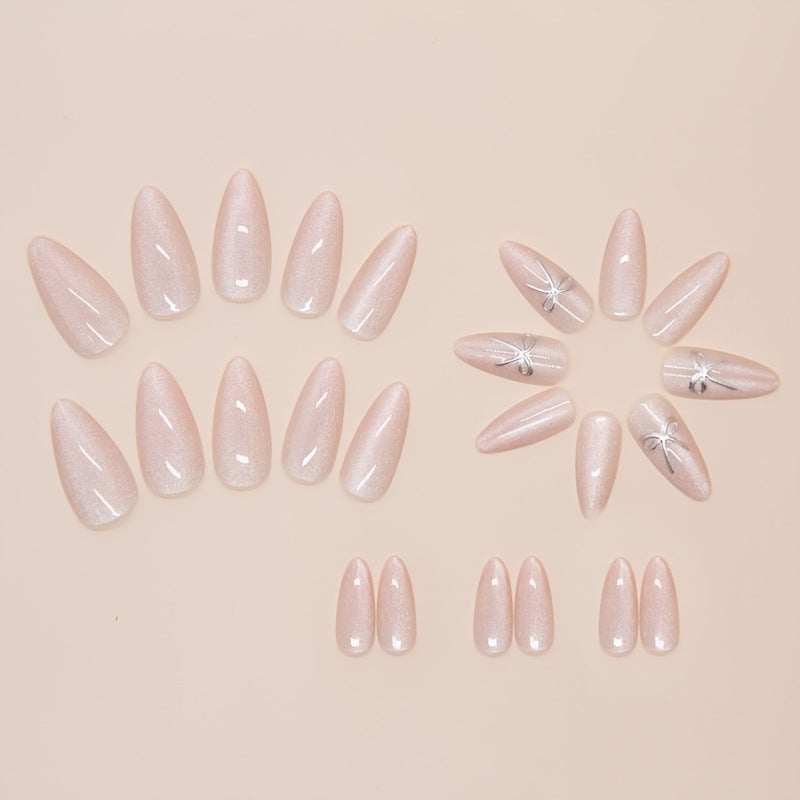 Artificial nail set with delicate glitter and elegant bow decorations Stornfield