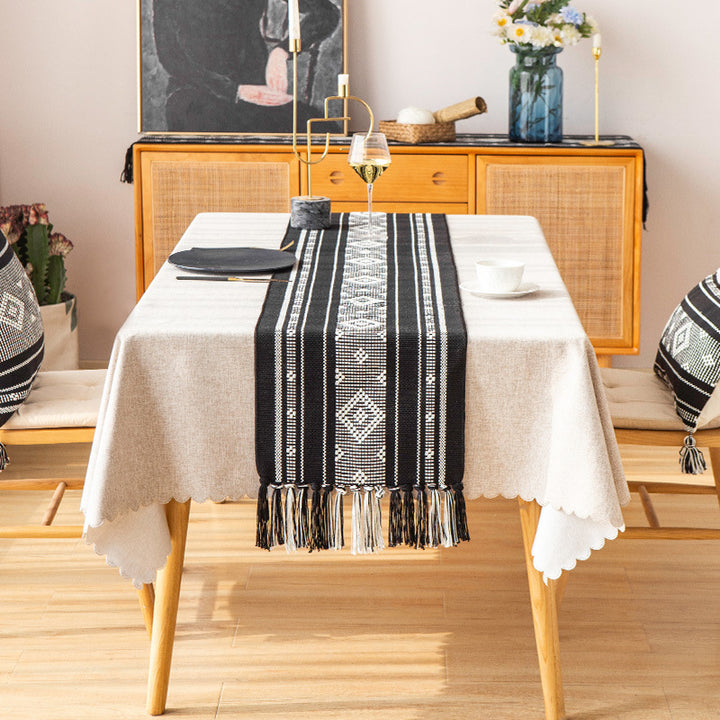 Handwoven table runner made of cotton blend with geometric weave pattern and fringe trim