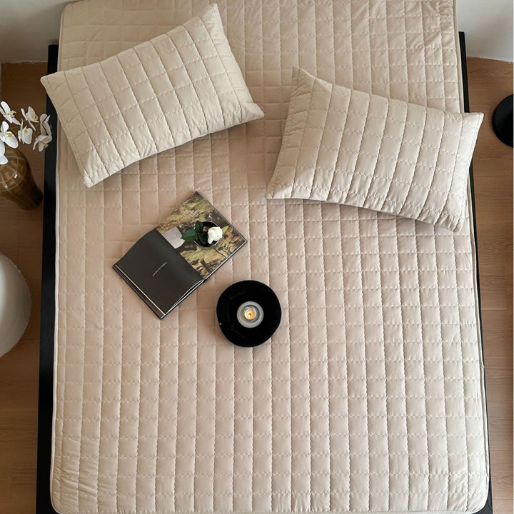 Padded quilted mattress topper with non-slip bottom and breathable fiber filling