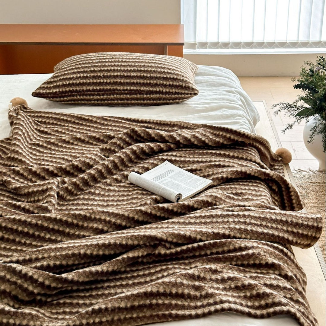Cozy living blanket with waffle structure and pom-pom cushion set
