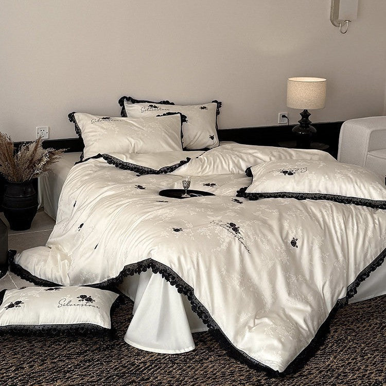 Luxurious satin bedding set with black lace trim and embroidered rose appliqués