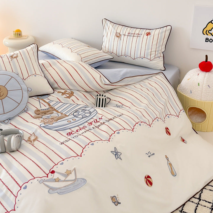 Children's bedding set with embroidered comic design and striped details