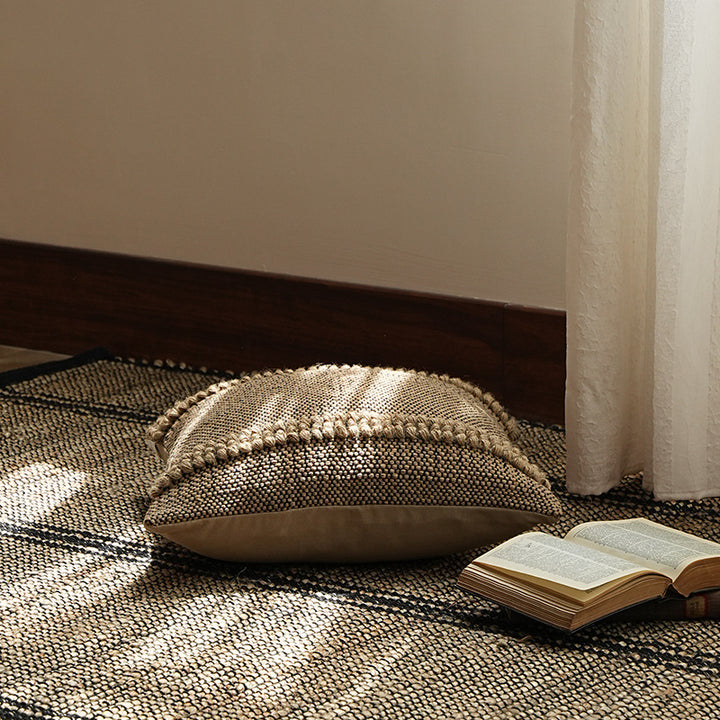 Square Boho decorative cushion made of coarsely woven cotton blend with decorative cord tufts