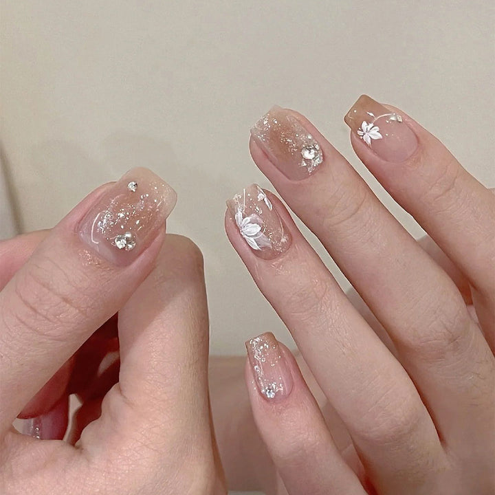 Elegant Nail Art with Holographic Accents and Floral Embellishments Stornfield