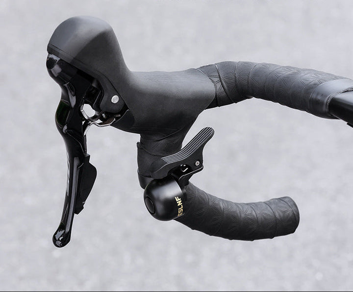 compact bicycle handlebar bell with quick release clamp and ergonomic thumb lever Stornfield