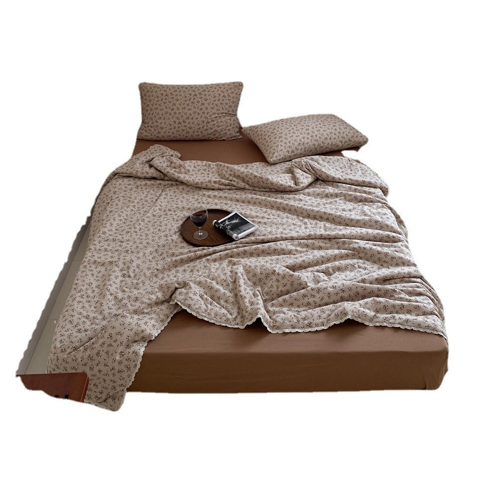 Quilted throw blanket made of cotton blend with delicate floral pattern and lace edge