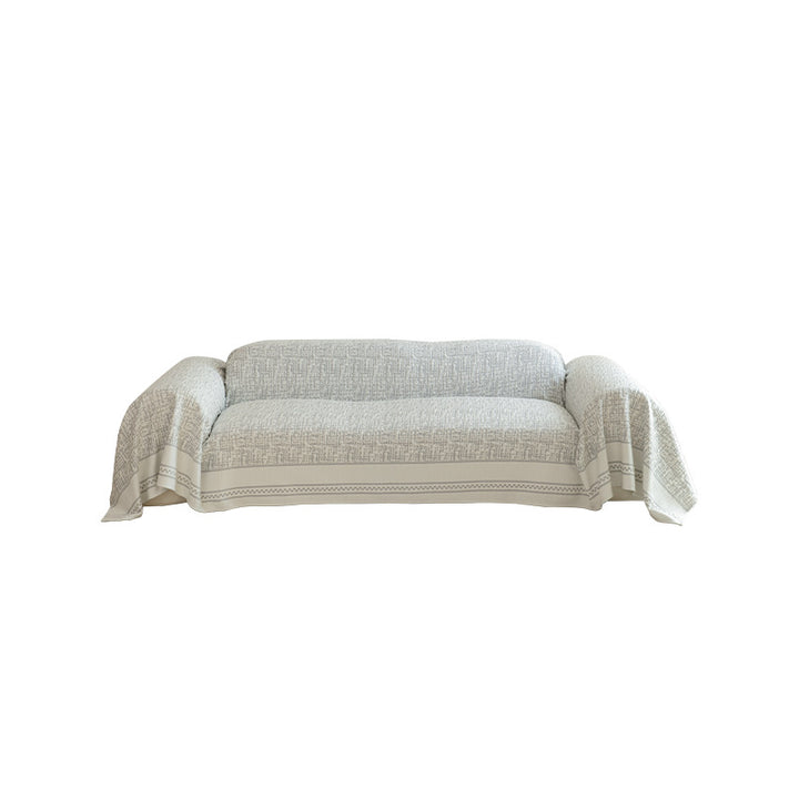 Geometric sofa cover made of cotton blend fabric with decorative fringe edge