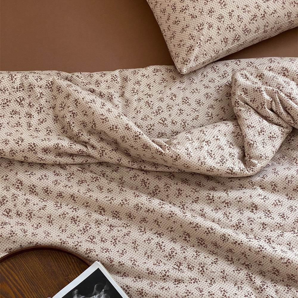 Quilted throw blanket made of cotton blend with delicate floral pattern and lace edge