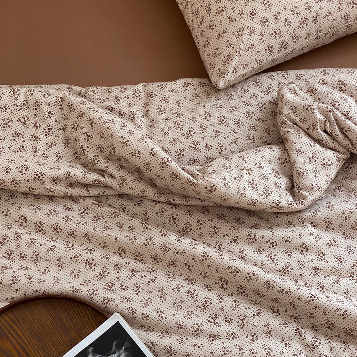 Quilted throw blanket made of cotton blend with delicate floral pattern and lace edge