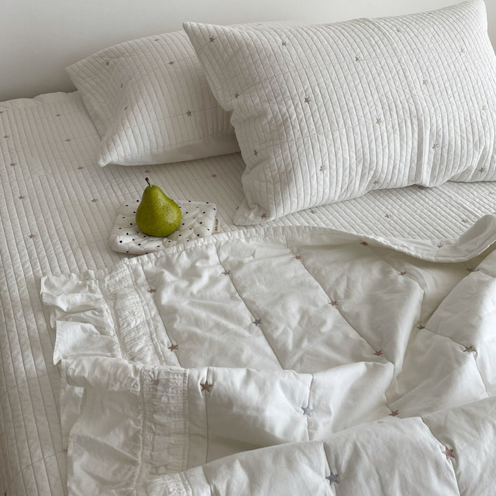 Quilted bedspread with delicate longitudinal stitching and matching pillowcases