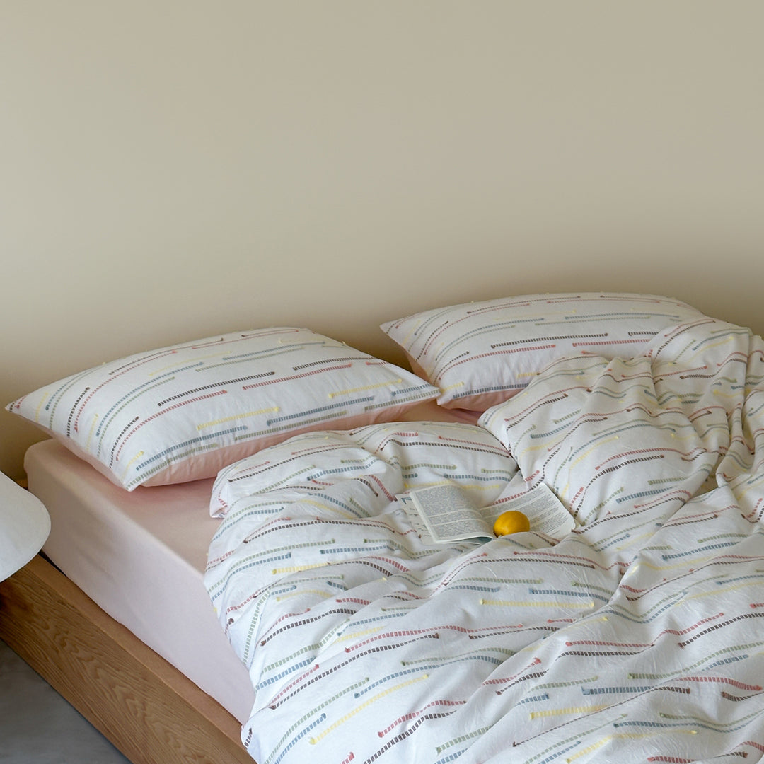 Bedding set made of cotton percale with subtle stripe and pompom design
