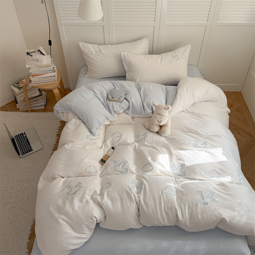 Quilted comforter with delicate bird and cloud embroidery