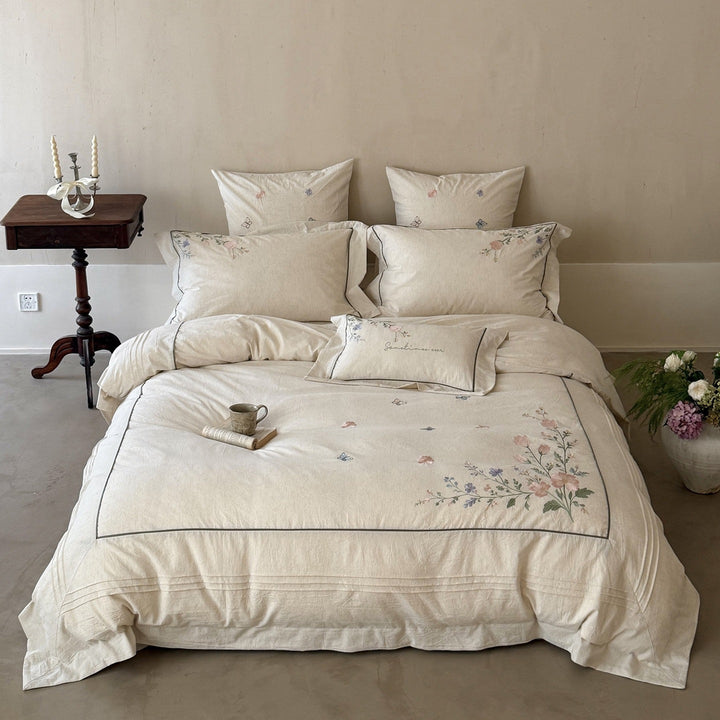 Natural fiber duvet cover set with delicate floral hand embroidery, linen look, and decorative ruffle