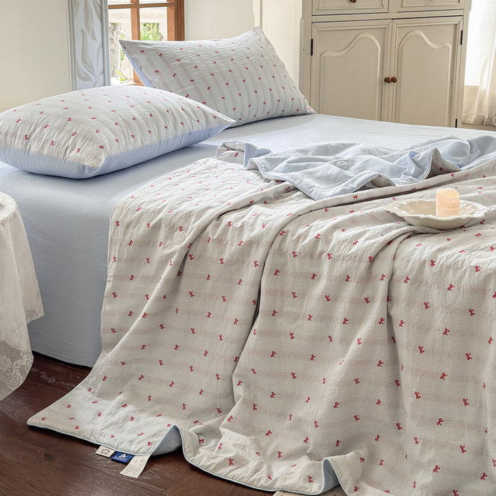 Quilt set in quilted cotton muslin with reversible function, delicate floral print and matching fitted sheet