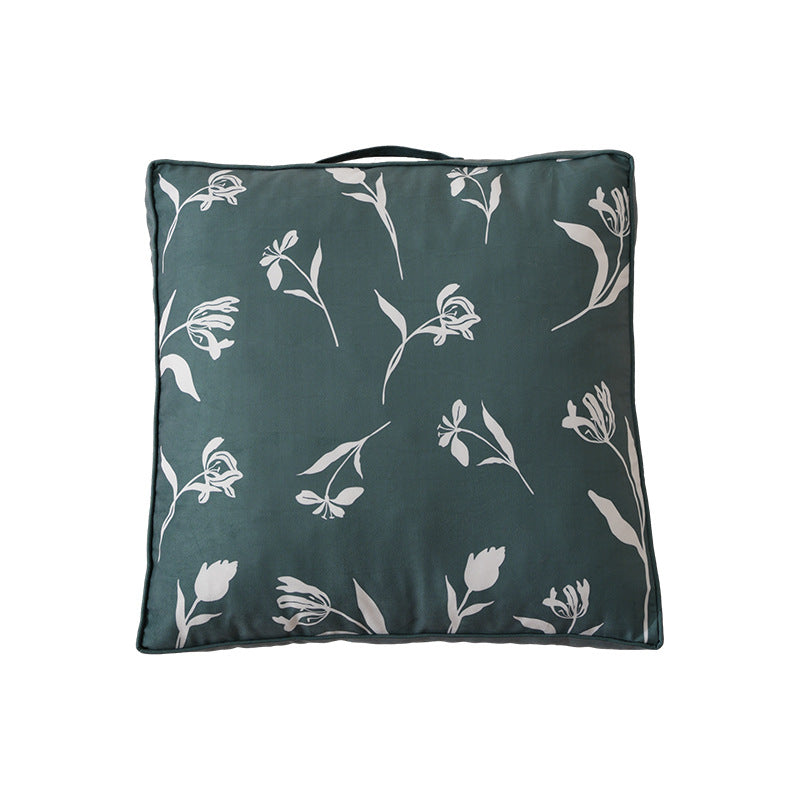 Padded floor cushion with quilted tufting, floral motif and carrying handle