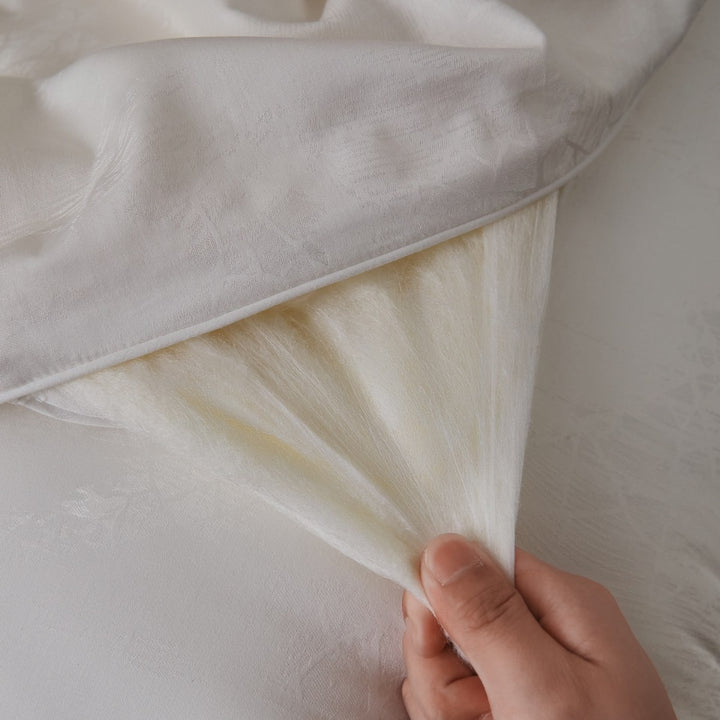 Quilted comfort duvet with fine jacquard structure and decorative button quilting