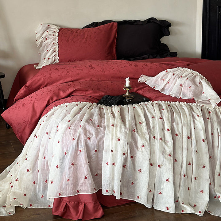 Ruffled bedskirt and pillowcases made of embroidered cotton-linen blend