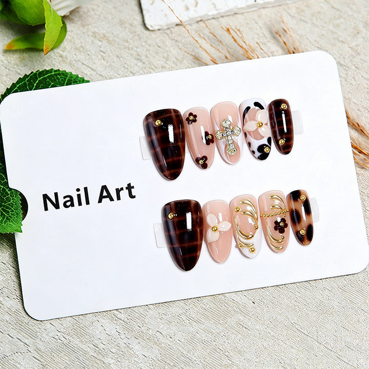 Artificial nails set with elegant gold accents and floral embellishments Stornfield