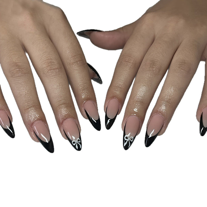 Acrylic nail set with elegant black and white design and cute bow accents Stornfield