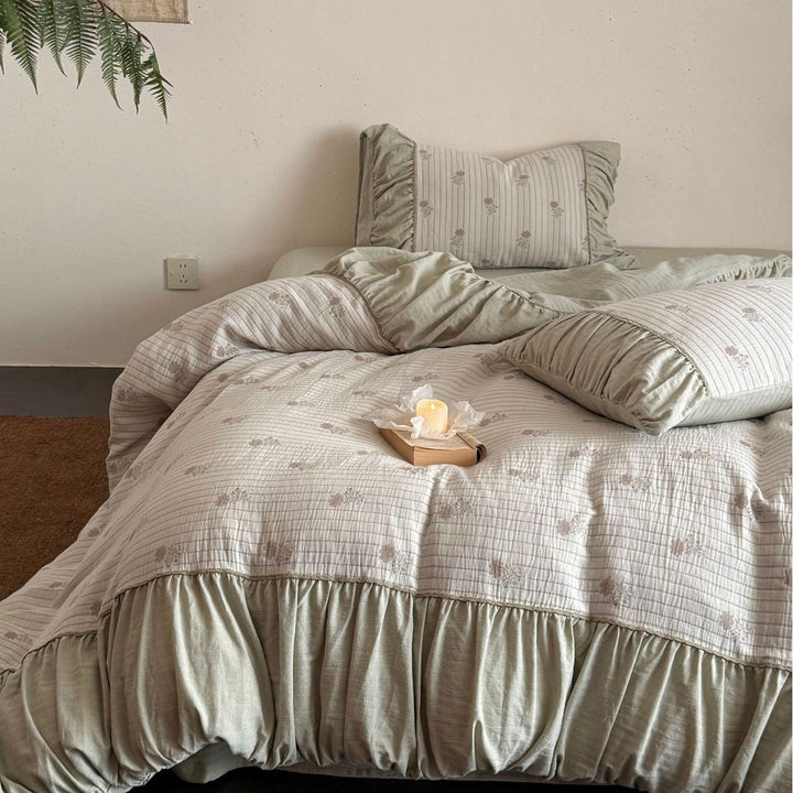 Padded bedding set with ruffled border, quilted bedspread and fine floral pattern