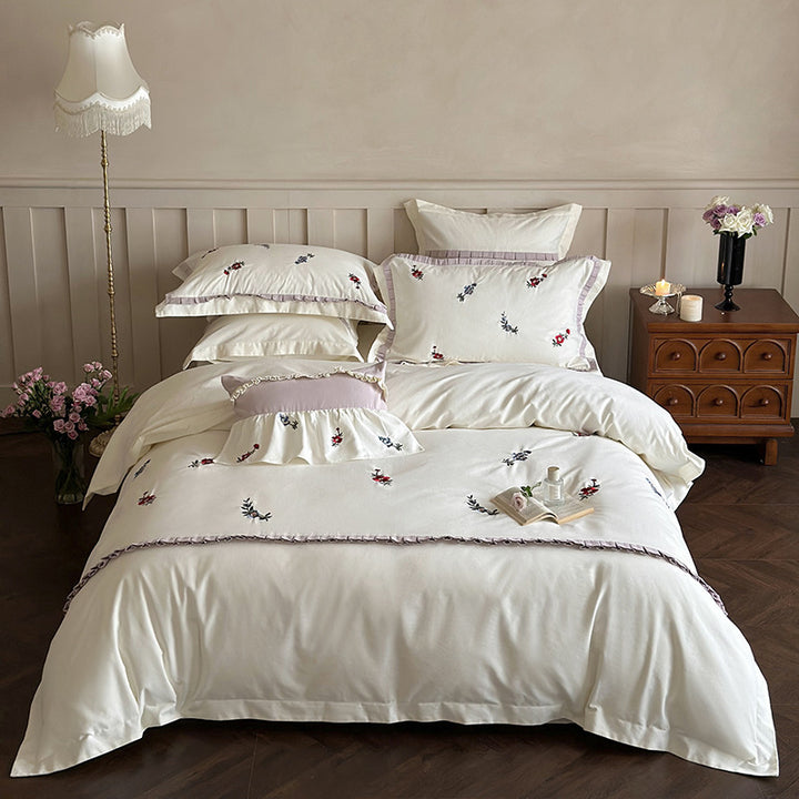 Duvet cover set made of premium cotton satin with subtly embroidered wildflower motif and ruffle edge