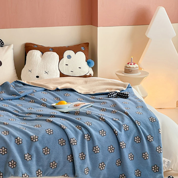 Reversible cuddly blanket made of teddy fleece and microfleece with floral pattern and fastening straps