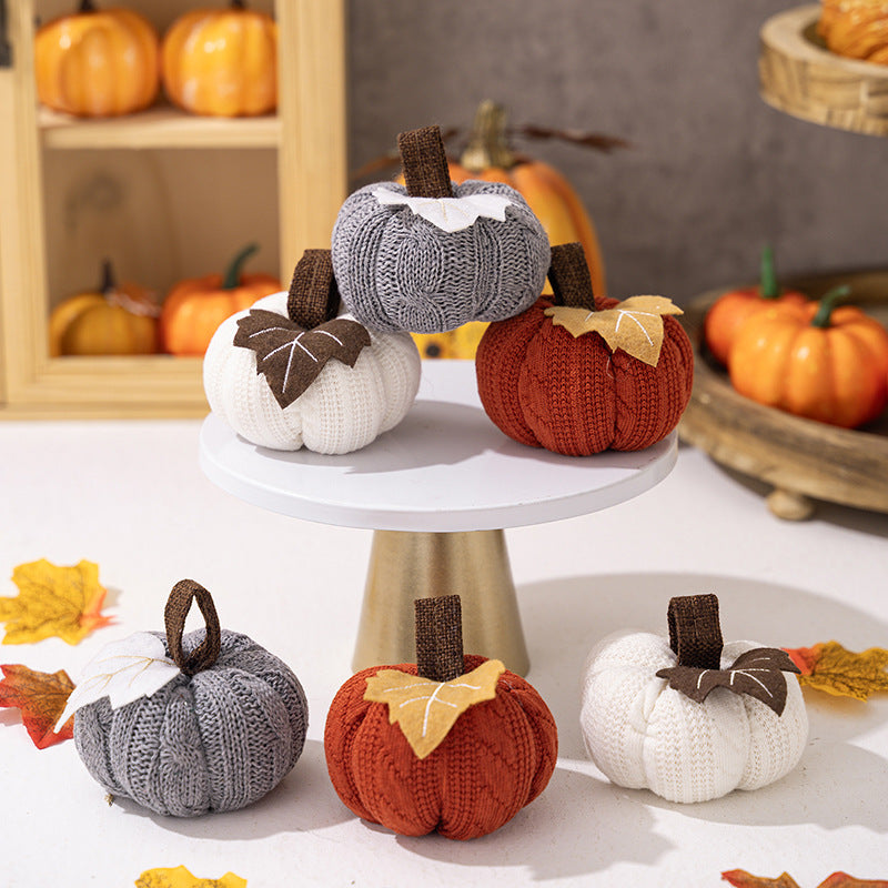 Knitted fabric pumpkin as autumn table decoration with felt leaf