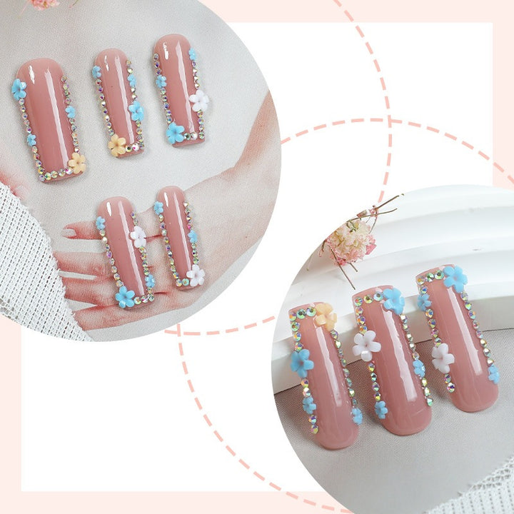 Artificial nail set with delicate flower embellishments and glitter accents Stornfield