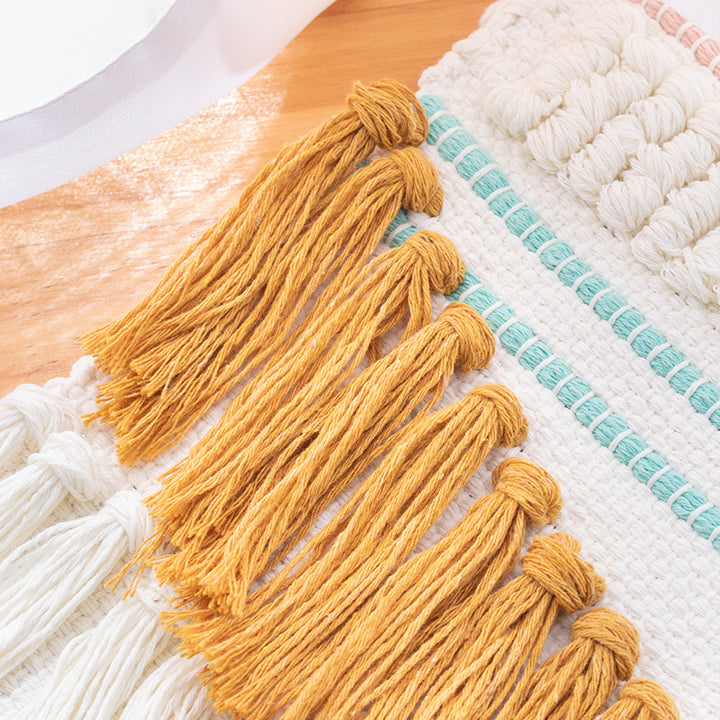Handwoven wall hanging in boho style with tassels and geometric structure