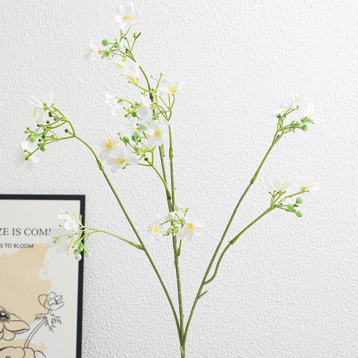Artificial flower branch with delicate blue flowers and green berries