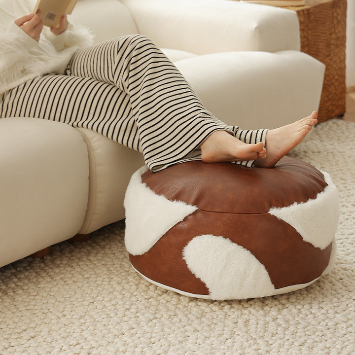 Round seating pouf with faux leather cover and Sherpa applications