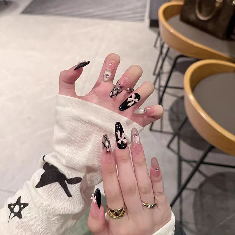 Artificial nails with playful bow design and glitter effects Stornfield