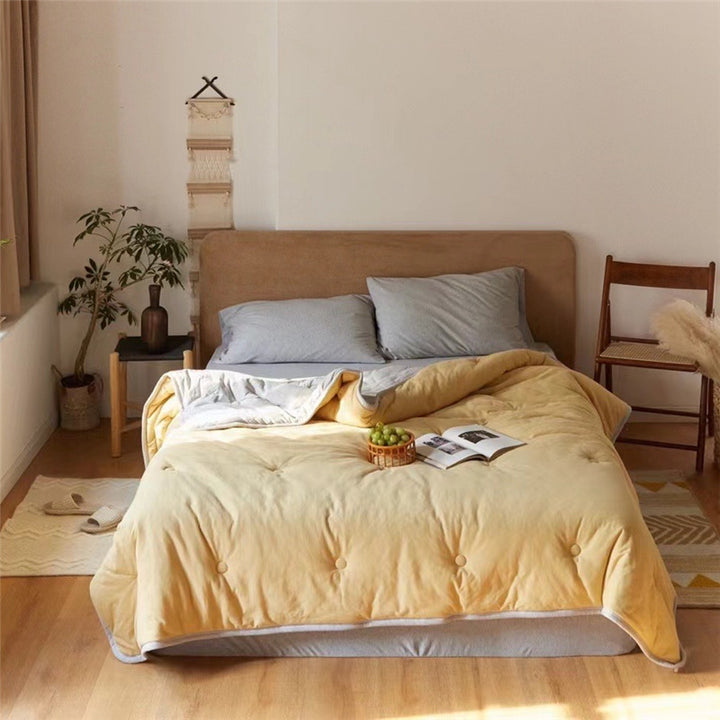 Light reversible quilted blanket made of microfiber with soft decorative stitching