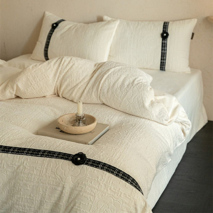 Quilted bedding set with decorative contrast ribbon and button closure