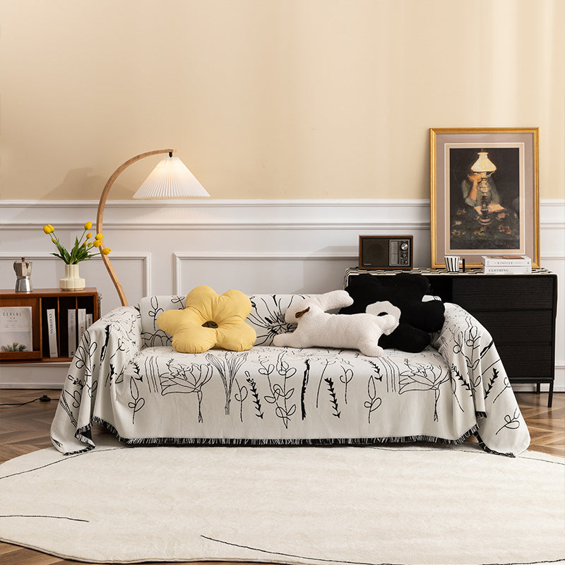 Light woven sofa cover with botanical line print and fringe hem